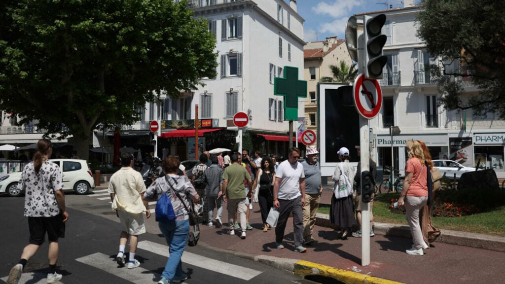 Des piétons traversent une rue à Cannes alors que les feux de circulation ne fonctionnent plus suite à une panne d'électricité dans le sud-ouest de la France, le 24 mai 2025. © Sameer Al-Doumy, AFP