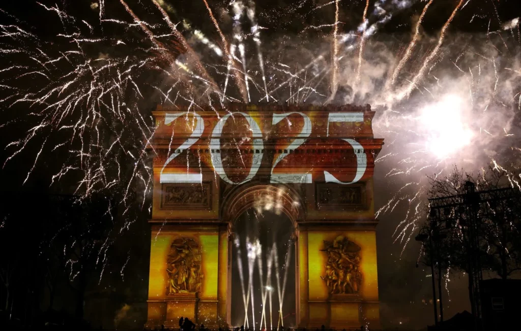 Fireworks illuminate the sky around the Arc de Triomphe on the Avenue des Champs-Elysees in Paris early January 1, 2025, during New Year celebrations. (Photo by Thomas SAMSON / AFP - Thomas Samson