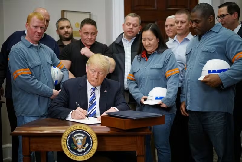 Donald Trump signe les déclarations imposant des droits de douane sur l’acier et l’aluminium, dans le bureau Ovale de la Maison Blanche, à Washington, le 8 mars 2018. ©MANDEL NGAN / AFP