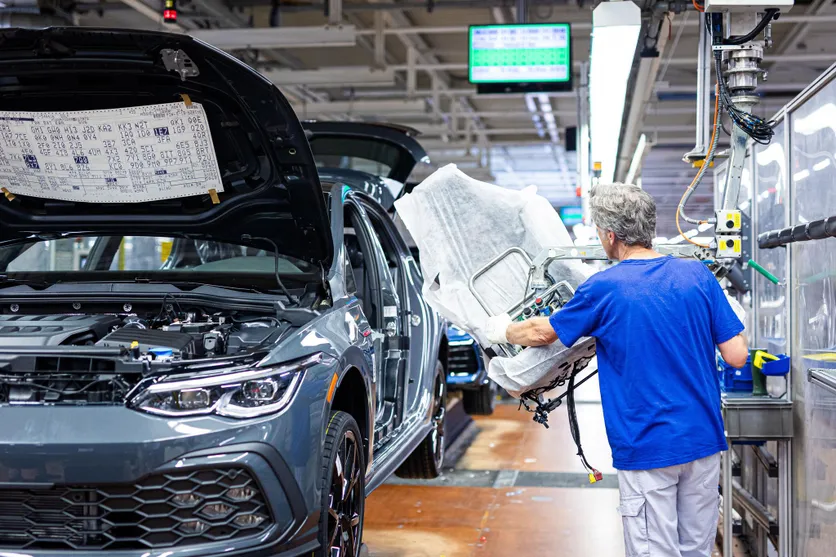 Un employé installe un siège de voiture dans un véhicule à l’usine Volkswagen de Wolfsburg, en Basse-Saxe, en mai 2024.