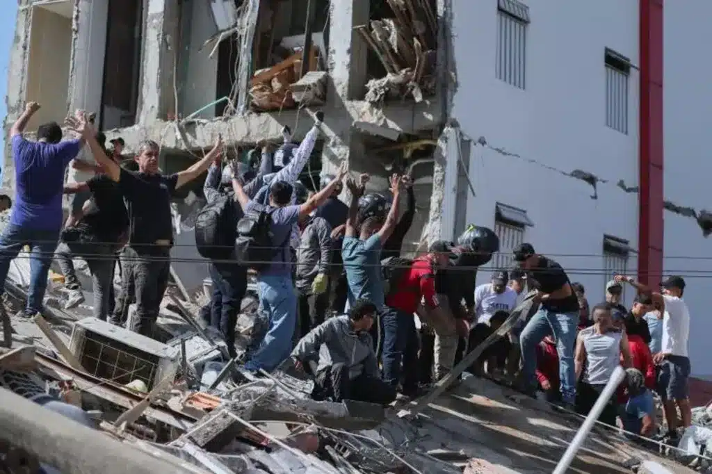 Des habitants aident les services de secours &agrave; fouiller les d&eacute;combres d'un b&acirc;timent effondr&eacute; &agrave; Cali, ce 10 ao&ucirc;t.