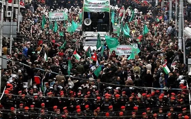 La police jordanienne en mission alors que les manifestants brandissent des drapeaux palestiniens et des Frères musulmans lors d'une manifestation contre la décision du président américain de reconnaître Jérusalem comme capitale d'Israël, dans la capitale jordanienne d’Amman, le 29 décembre 2017. (Khalil Mazraawi / AFP)