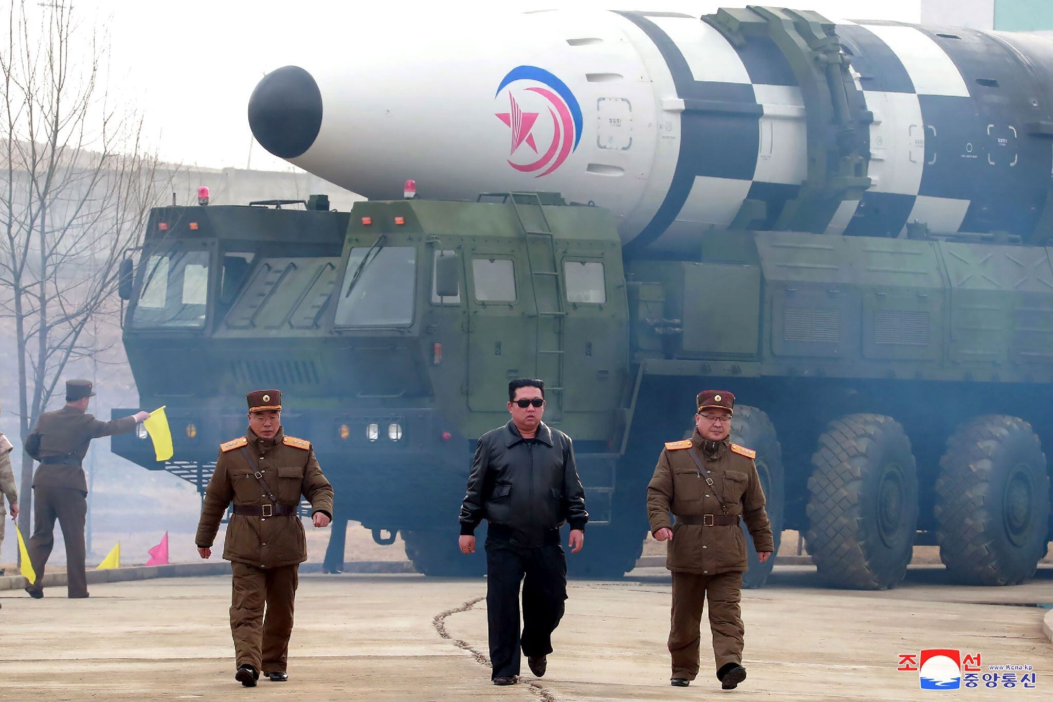 Photo diffusée le 25 mars 2022 par l'agence nord-coréenne Kcna du dirigeant nord-coréen Kim Jong Un (c) devant un missile balistique intercontinental Hwasong-17 dans un lieu non précisé en Corée du Nord, le 24 mars 2022 ©afp.com/STR