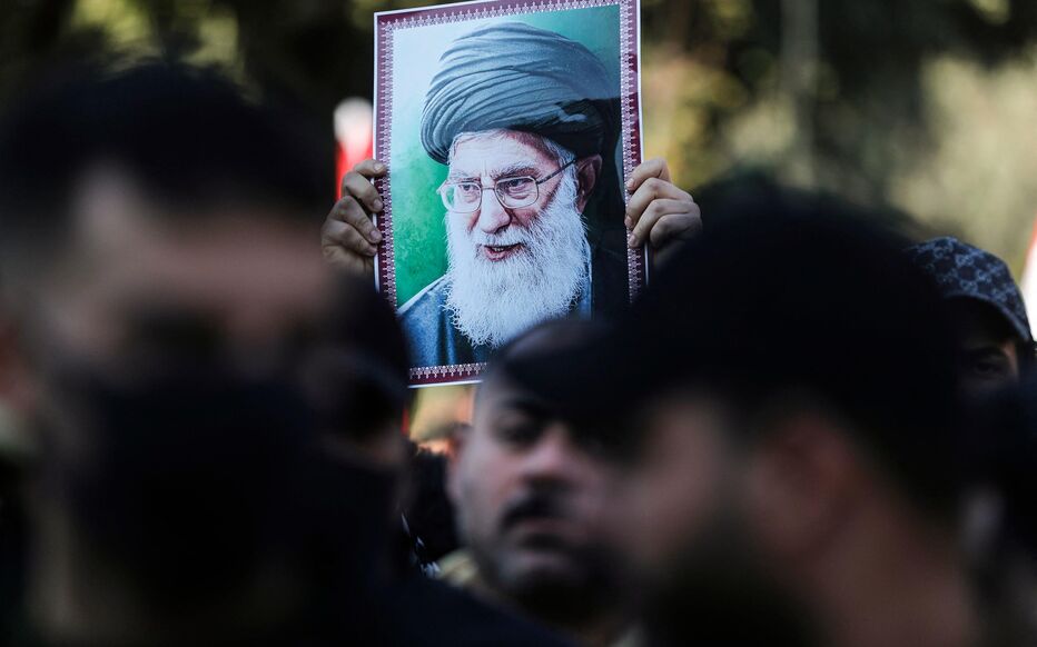 A protester holds up a portrait of Iran's Supreme Leader Ayatollah Ali Khamenei during a demonstration near the Iranian embassy in Baghdad on January 16, 2026, against Israel and recent US threats of military action in Iran, and in support of the Iranian regime and its supreme leader. The protest movement in Iran has subsided after a crackdown that has killed thousands under an internet blackout, monitors said on Januray 16, one week after the start of the biggest protests in years challenging the Islamic republic's theocratic system. The threat of new military action by the United States against Iran has also appeared to have receded for the time being, with a Saudi official saying Gulf allies have persuaded President Donald Trump to give the Iranian leadership a "chance". (Photo by AHMAD AL-RUBAYE / AFP)