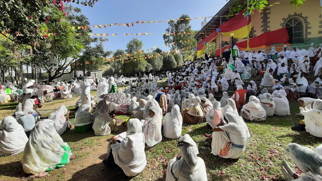 P&acirc;ques 2024, autour de l&rsquo;&eacute;glise Lideta Mariam, des dizaines de croyants &eacute;coutent les sermons, drap&eacute;s de leur &laquo;gabi&raquo;, la couverture traditionnelle en coton blanc.