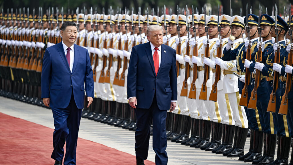 Le président américain Donald Trump (droite) et son homologue chinois Xi Jinping passent des troupes en revue le 14 mai 2026 à Pékin. © Kenny Holston, pool via AFP﻿