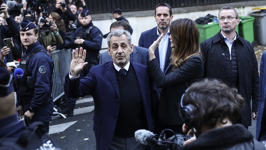 L’ancien président français Nicolas Sarkozy (au centre) et son épouse, Carla Bruni (à droite), saluent les manifestants le jour de son incarcération, lors d’une manifestation de soutien à Paris, le 21 octobre 2025. © EPA - TERESA SUAREZ