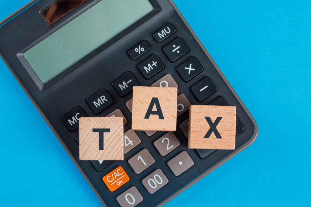 tax-planning-concept-with-wooden-cubes-calculator-blue-table-flat-lay